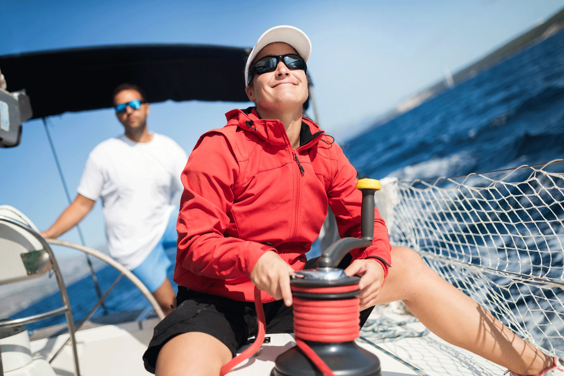 woman at sailboat helm, beaming with confidence after successful rehab treatment