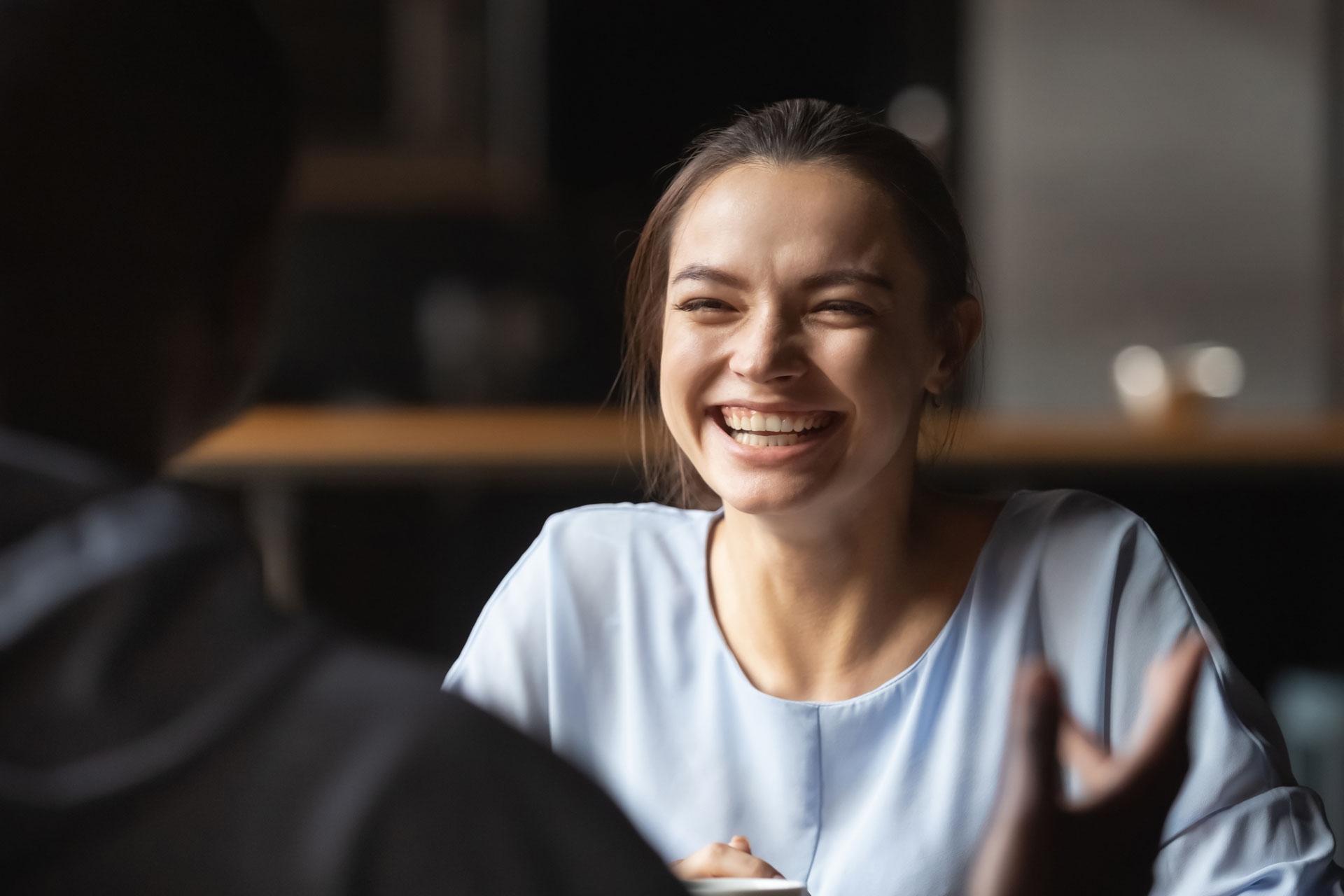 A woman smiling broadly in a therapy session, indicative of positive engagement A woman smiling broadly in a therapy session, indicative of positive engagement