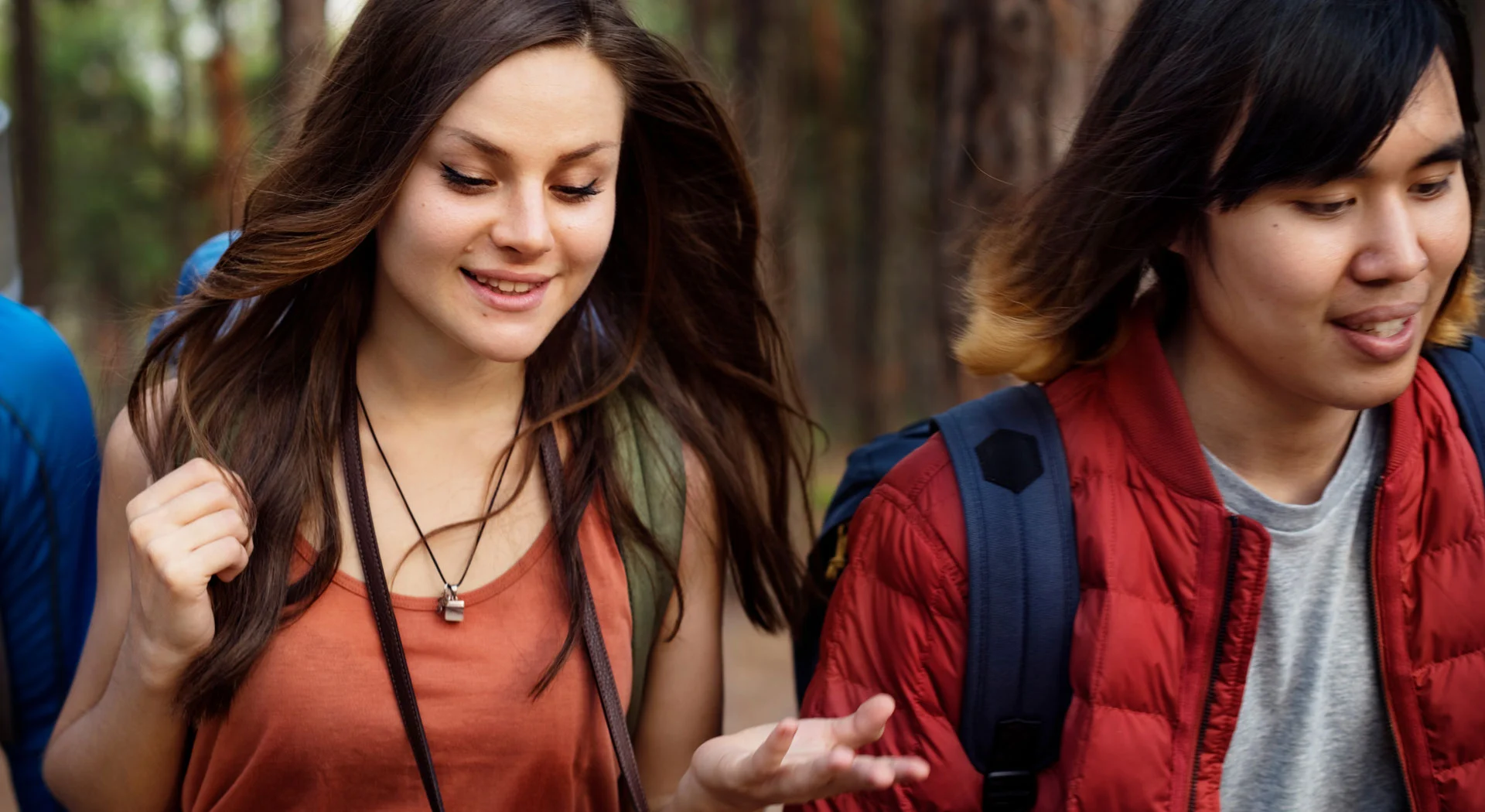 two people walking and talking in the woods, possibly part of a therapeutic outdoor activity