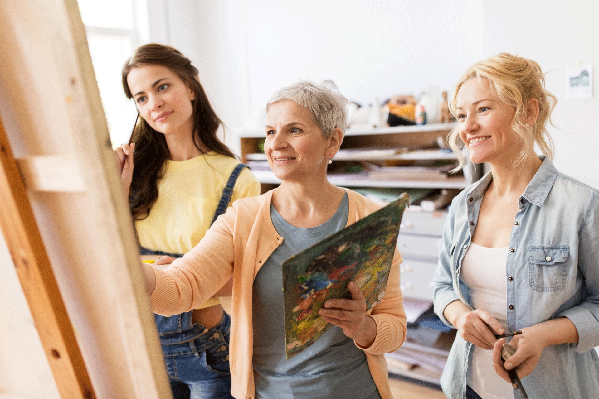 Three Women Enjoying A Painting Class, An Activity Beneficial For Mental Health And Anxiety Therapy three women enjoying a painting class, an activity beneficial for mental health and ptsd therapy