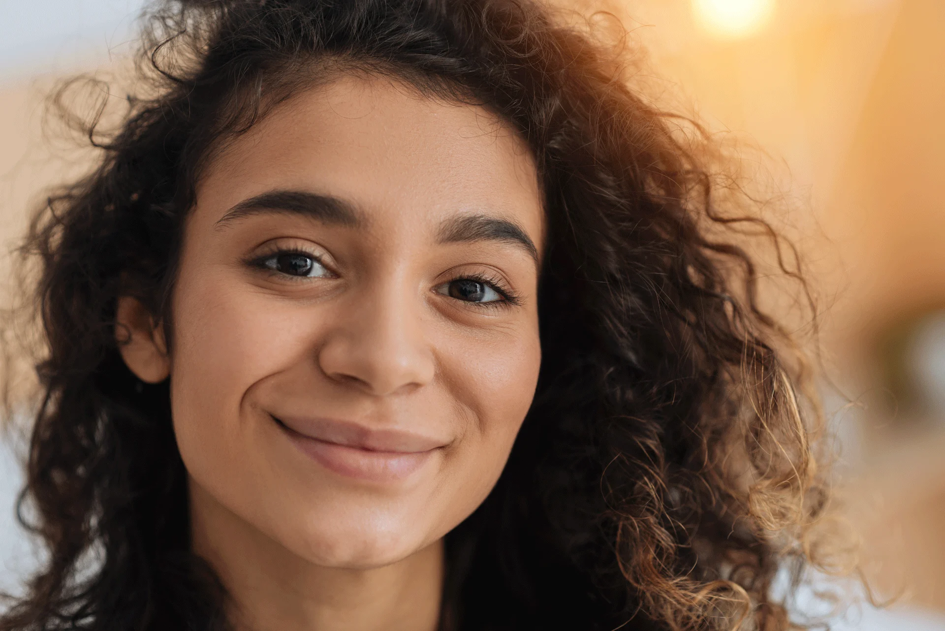 contented young woman with curly hair exemplifying the supportive community at big sky treatment.