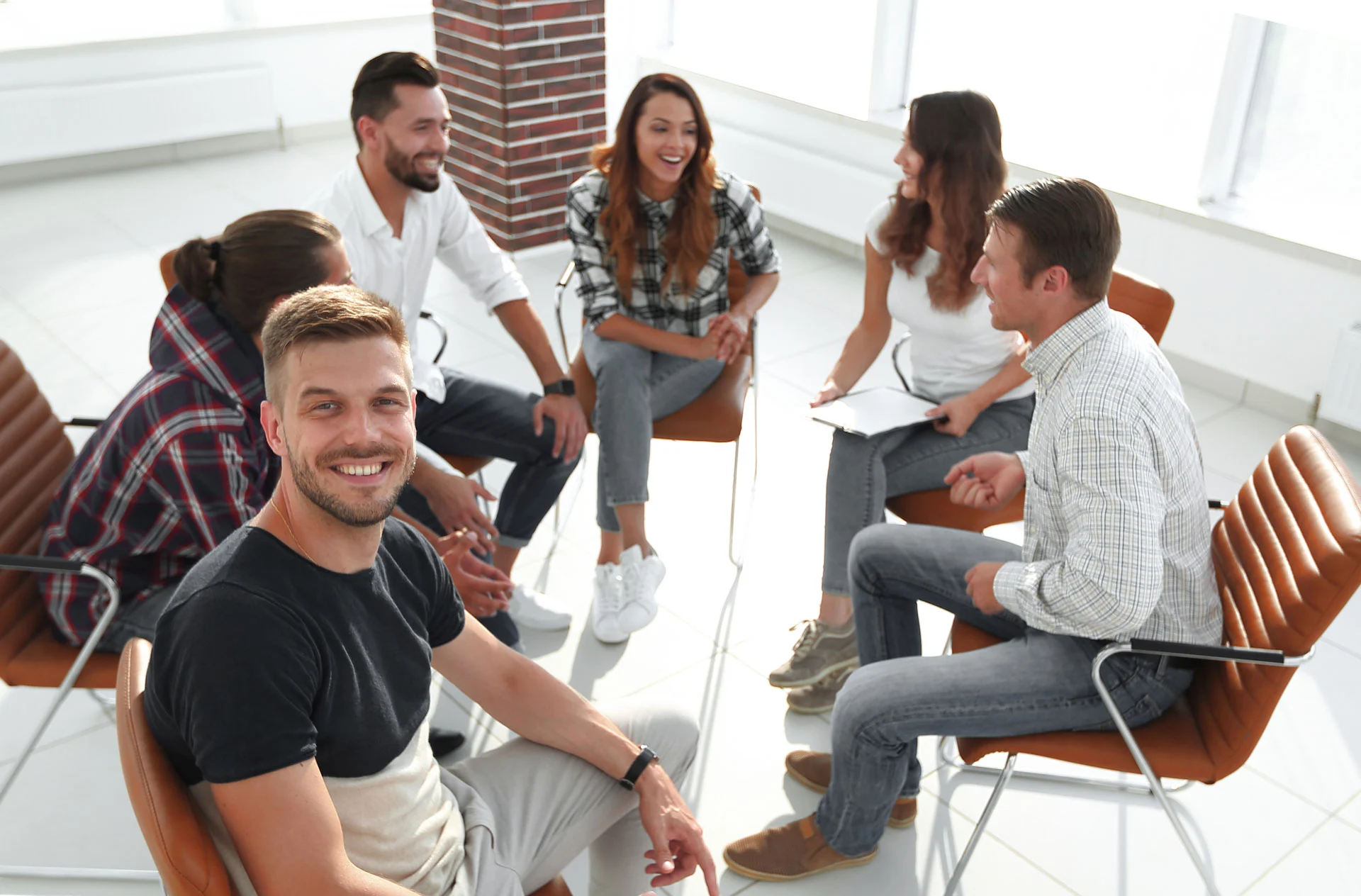 group of people smiling and interacting in a fentanyl addiction treatment support group.