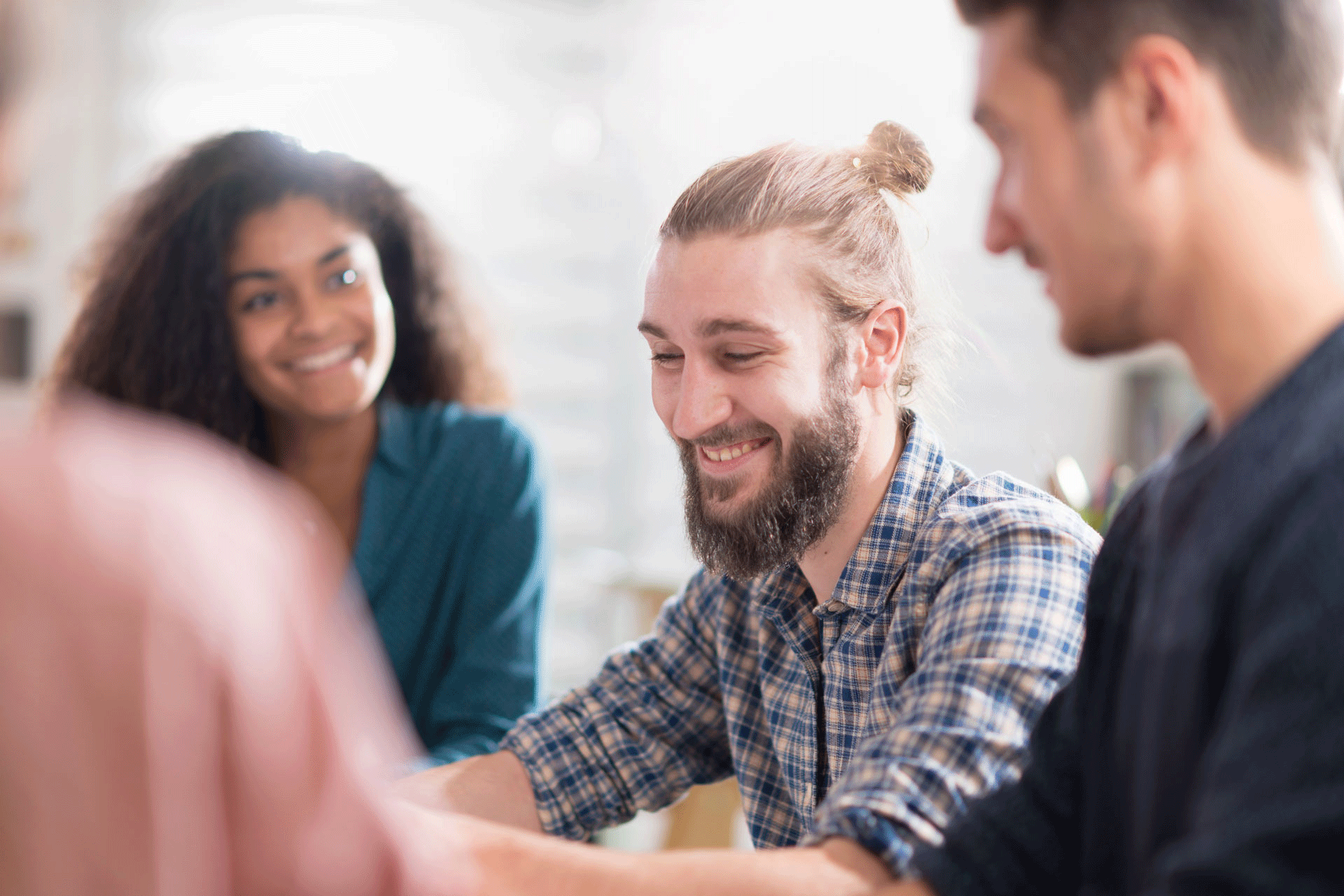 A group of cheerful people having a friendly conversation, with one man smiling broadly, exemplifying the communal support found in aftercare treatment services A group of cheerful people having a friendly conversation, with one man smiling broadly, exemplifying the communal support found in aftercare treatment services