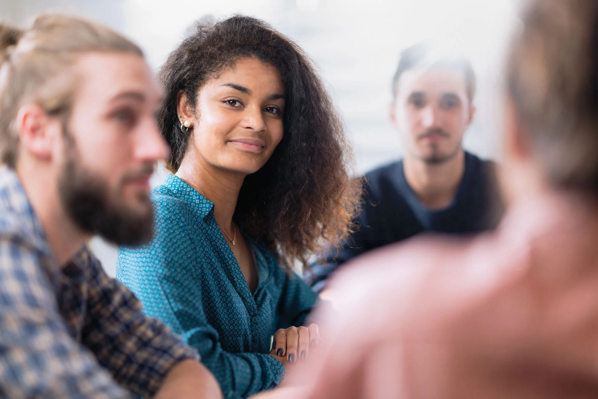 a smiling woman surrounded by a support group
