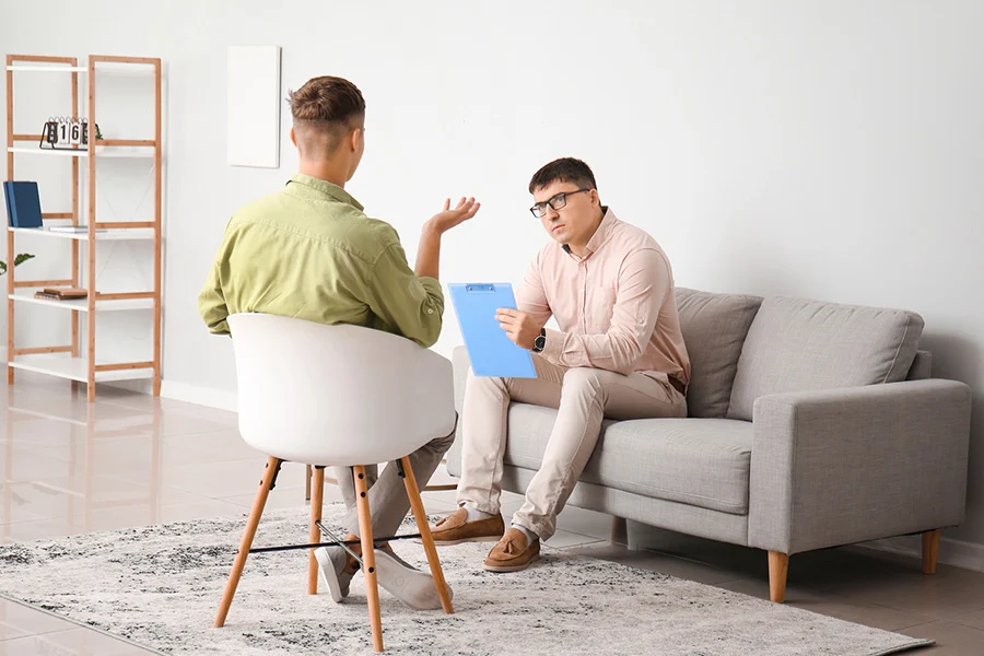 a counselor listens to a client during a therapy session, highlighting integrated allegiance by cigna dual diagnosis treatment.