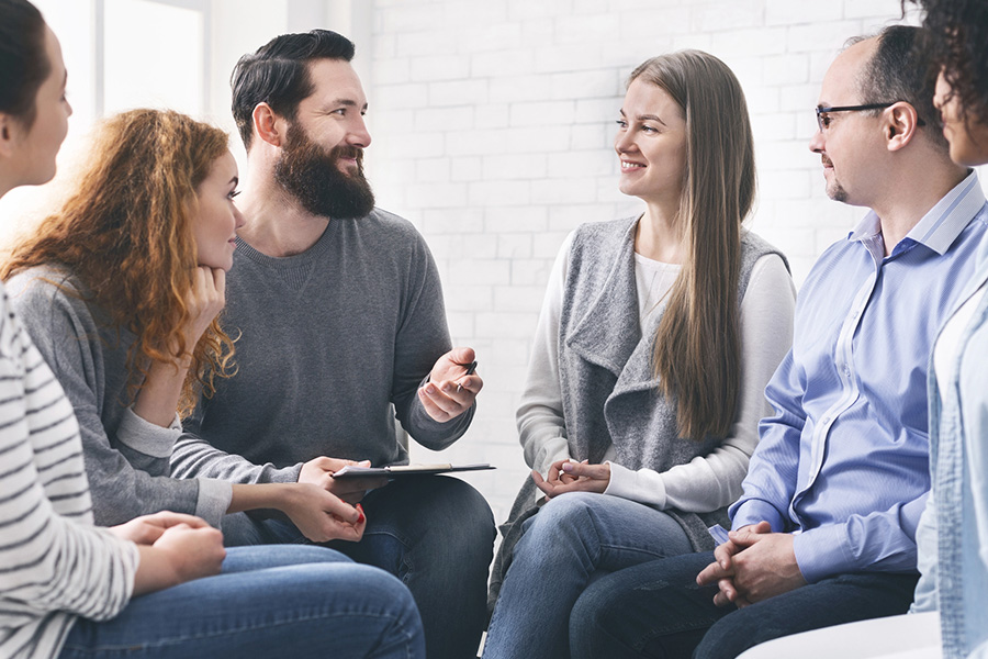 a diverse group in a support circle for mental disorders and addiction treatment, sharing their recovery stories.