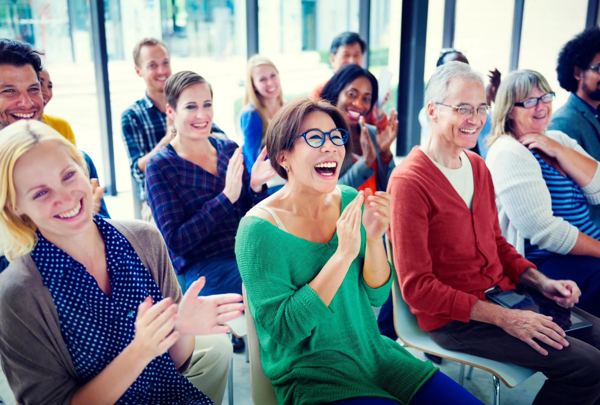 A Diverse Group Of People Laughing And Clapping Together In A Bright Room, Showcasing The Community Support Available Through Montana Medicaid Addiction Coverage. a diverse group of people laughing and clapping together in a bright room, showcasing the community support available through montana medicaid addiction coverage.