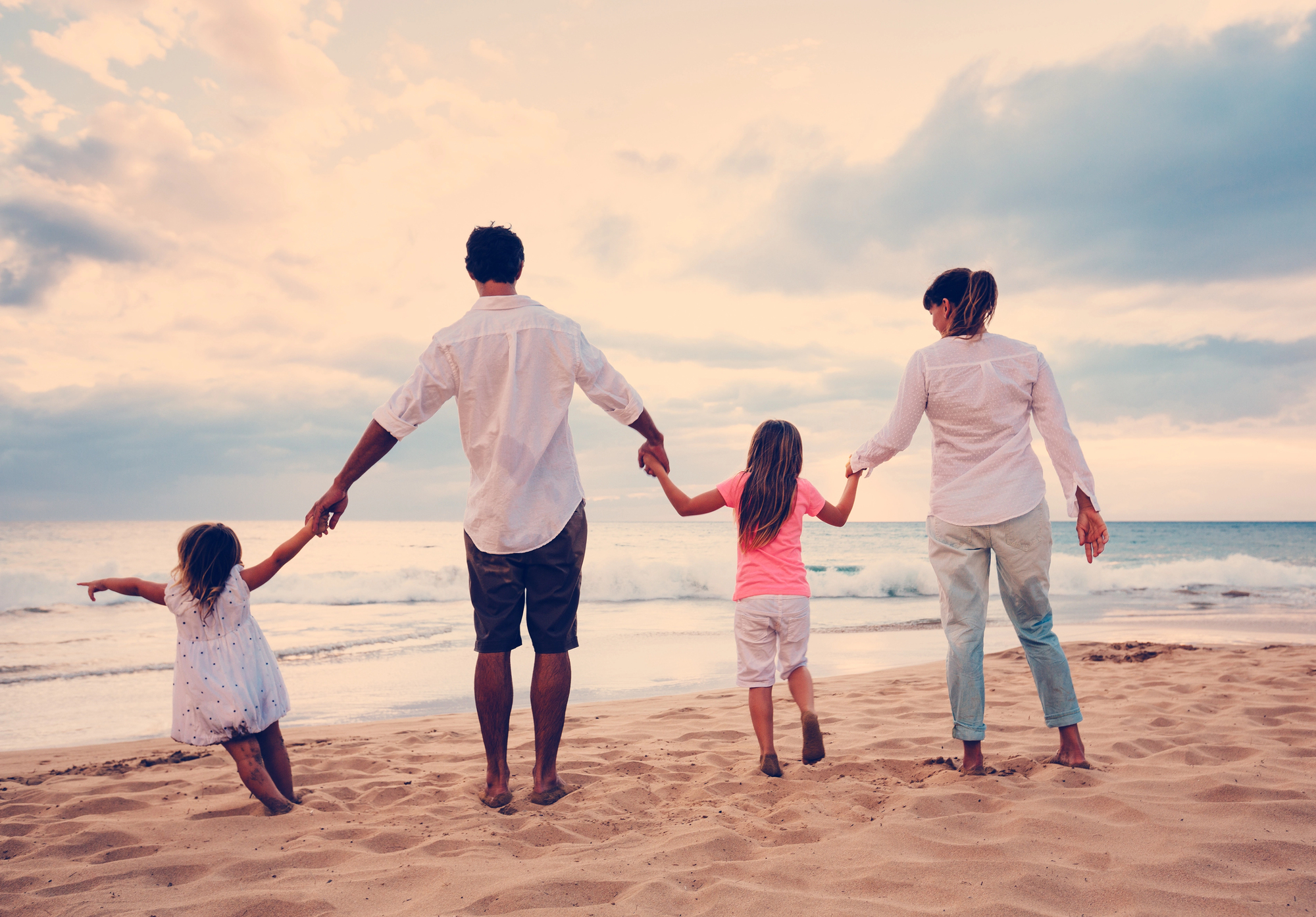 A family holding hands on a beach, symbolizing togetherness and well-being, reflecting PacificSource mental health coverage