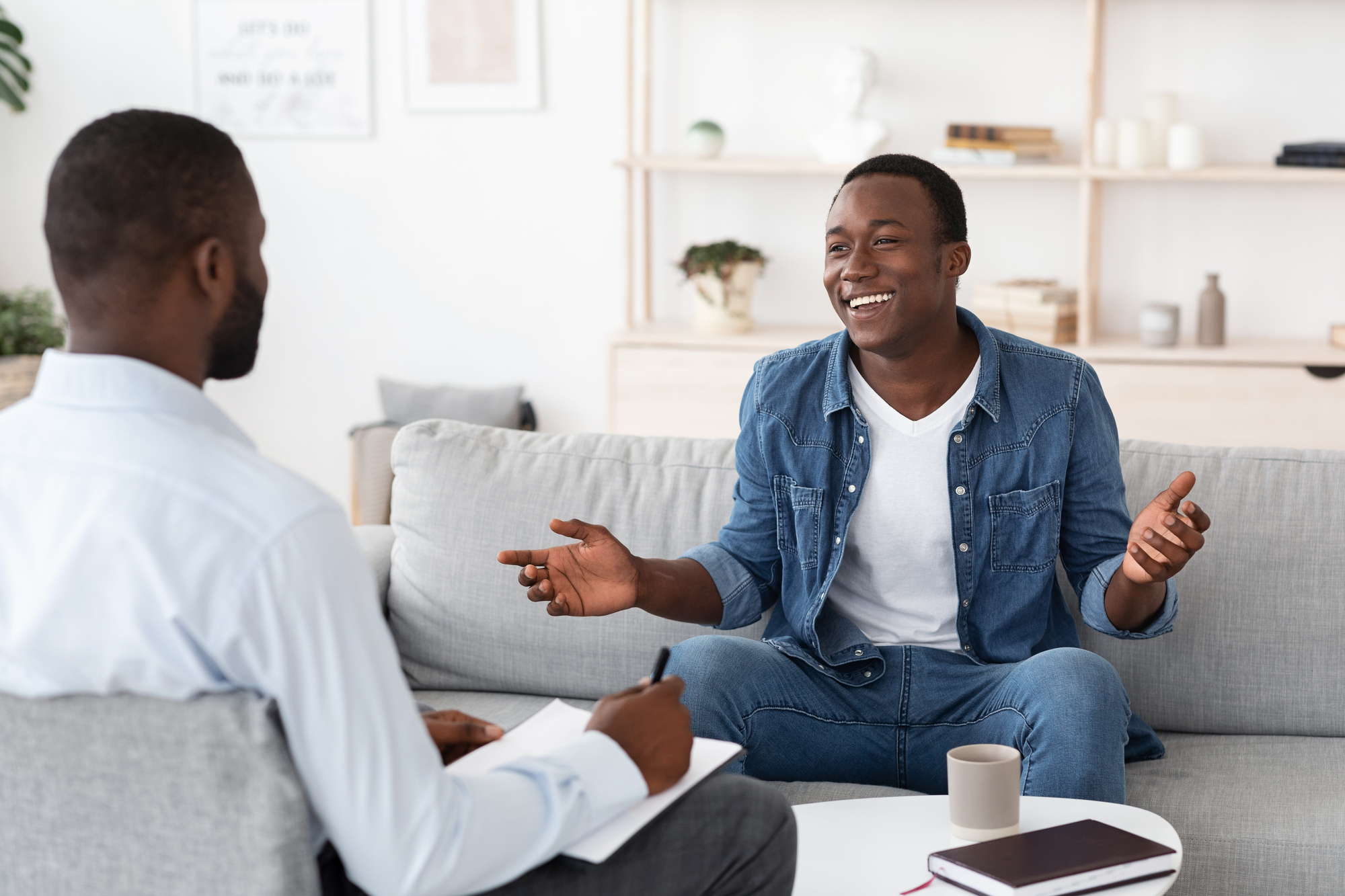 A smiling man talking to an admission counselor in a comfortable office, illustrating support during the admissions process