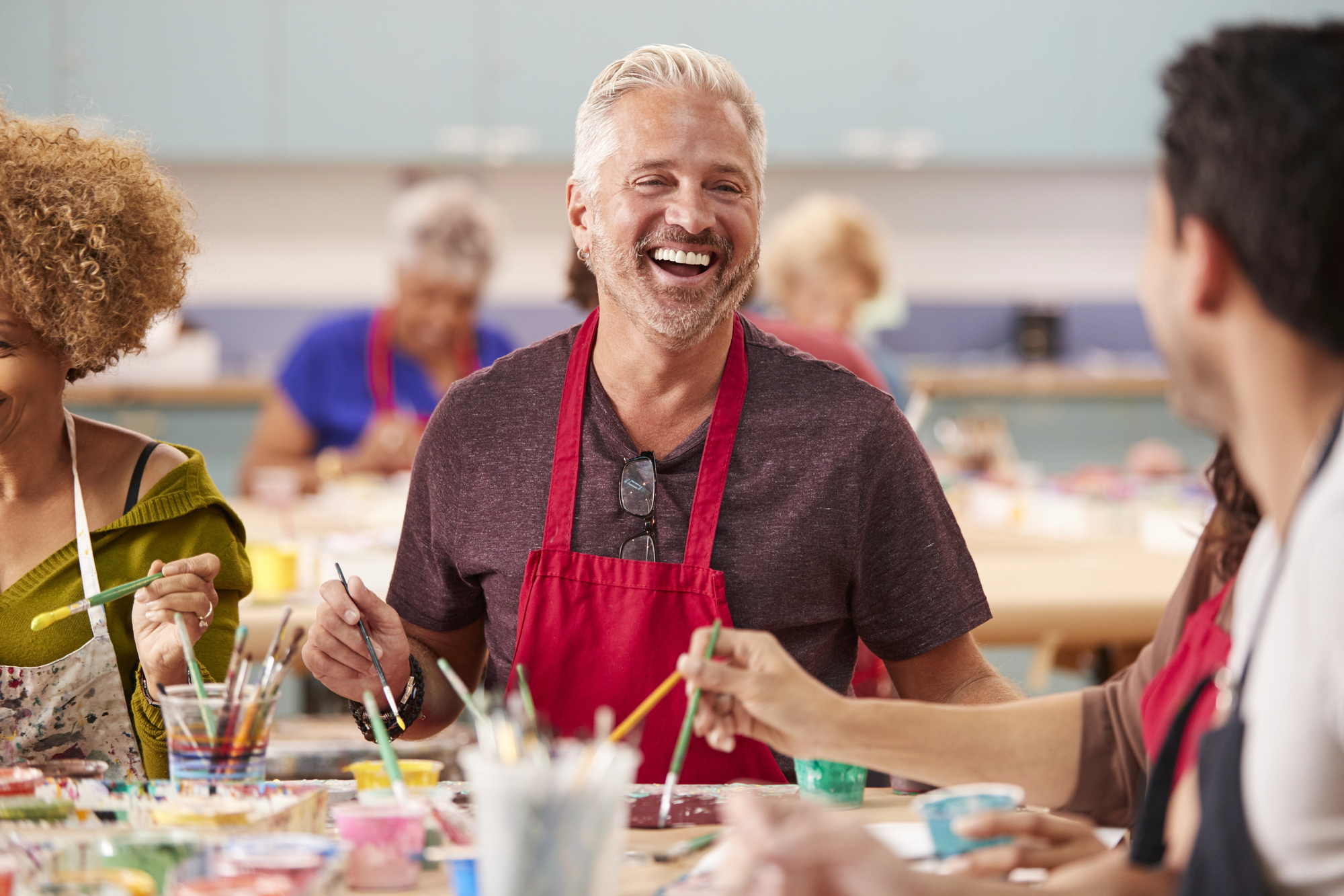 A veteran smiling engaged in art therapy for mental health and drug addiction treatment.