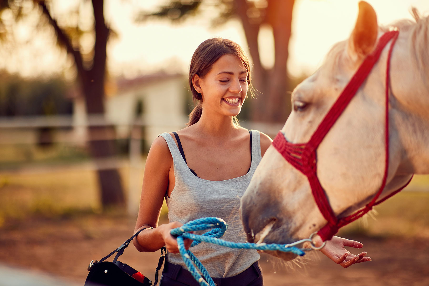 A woman smiles while interacting with a horse during an equine therapy session, highlighting Kratom treatment options A woman smiles while interacting with a horse during an equine therapy session, highlighting Kratom treatment options