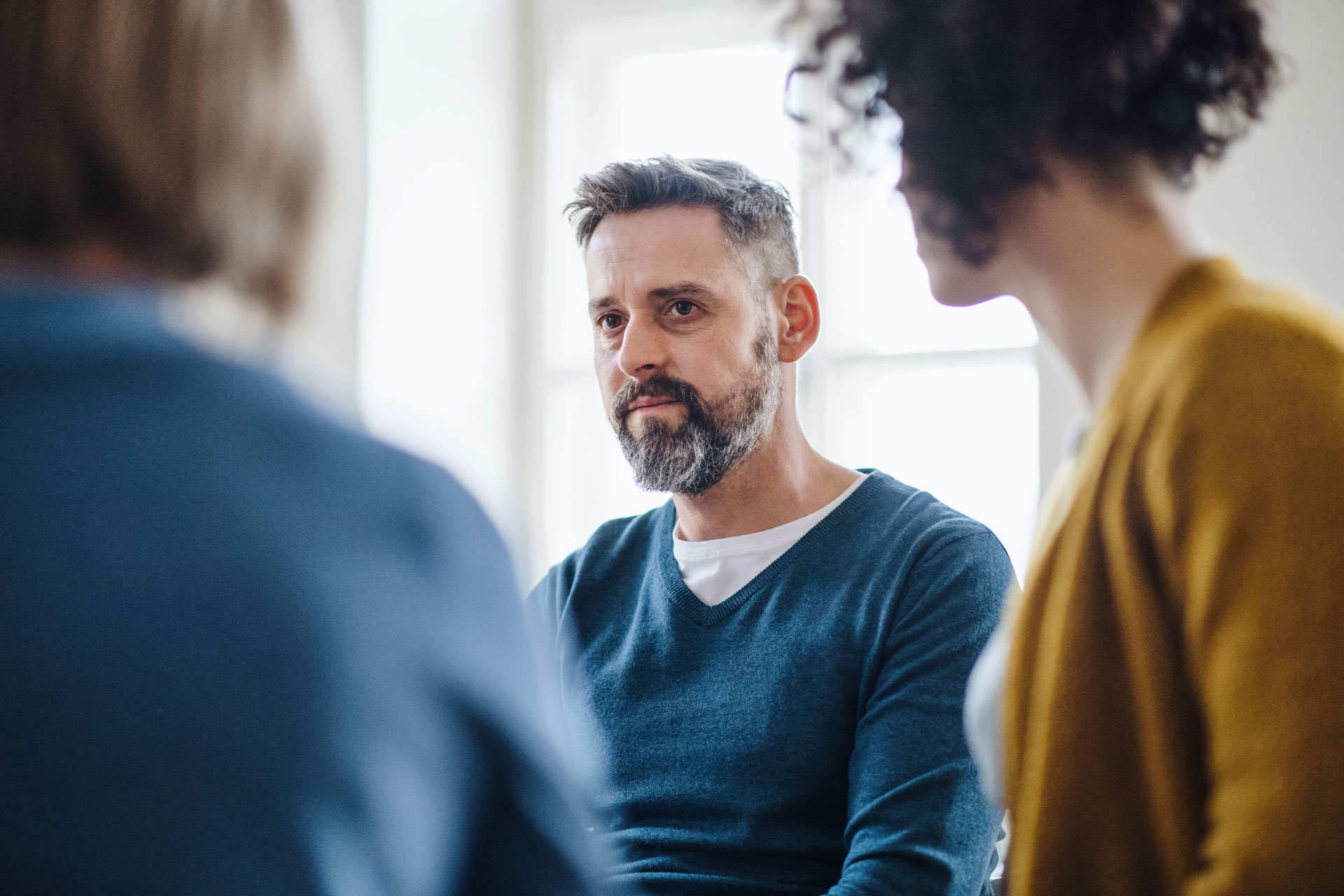 Man engaged in a serious group therapy discussion, possibly related to substance abuse recovery Man engaged in a serious group therapy discussion, possibly related to substance abuse recovery