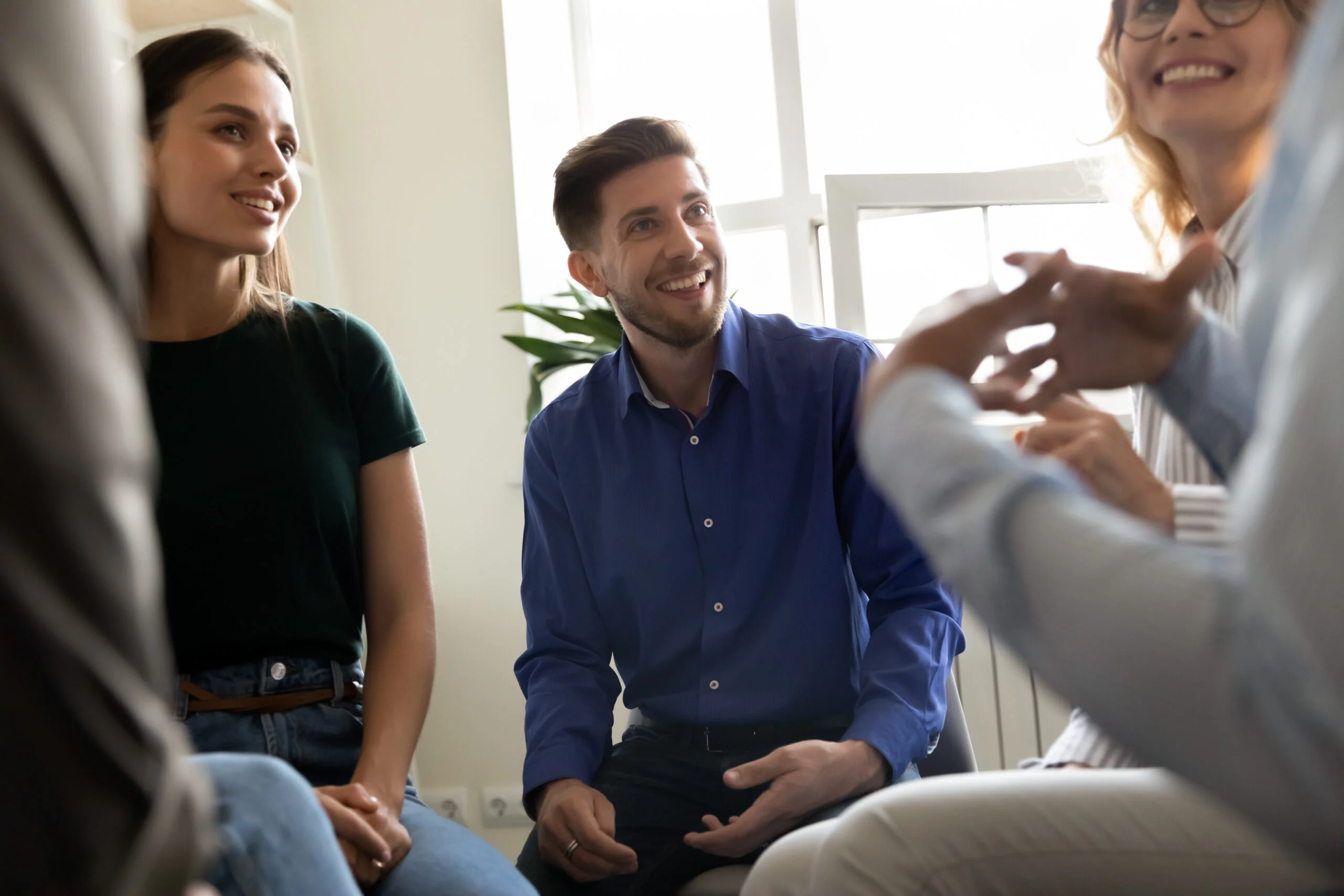 focus on a man smiling and listening attentively, representing a supportive group setting for evidence-based dual diagnosis care