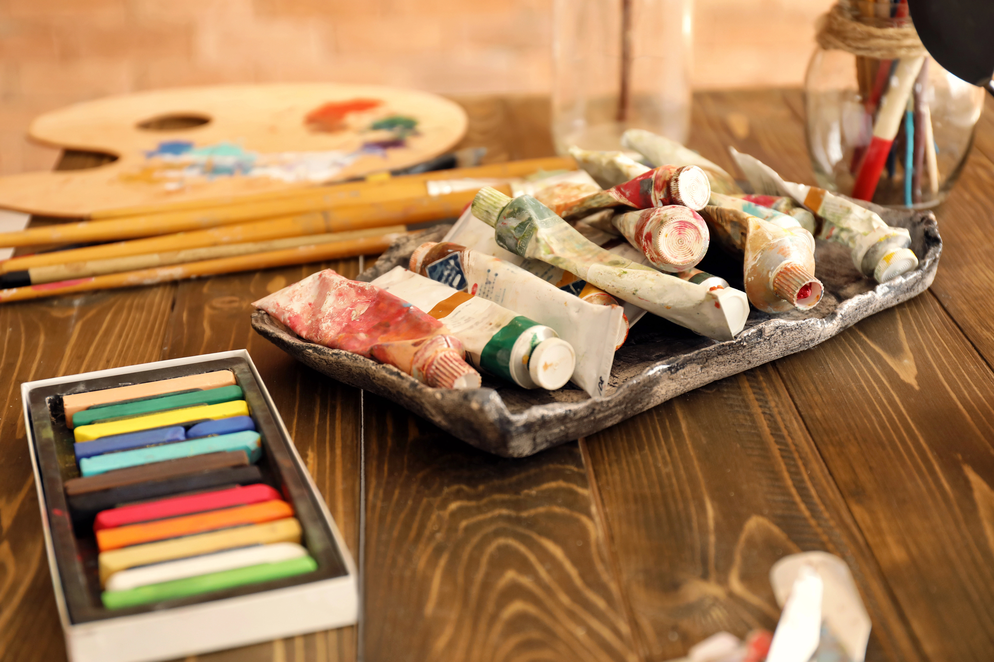 Art tools including paints, brushes, and other coloring materials arranged in a serene environment, representing the nurturing space at BIG SKY Treatment for personal growth
