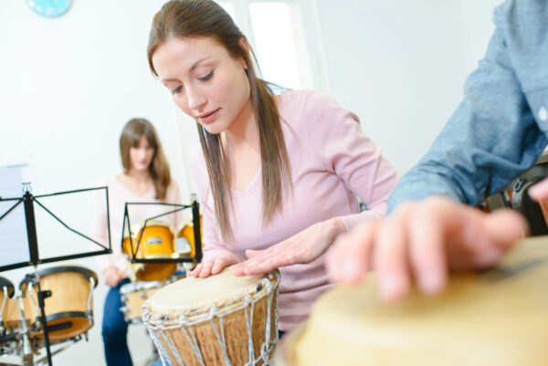 Closeup of a woman playing a drum helping to reduce anxiety and promote emotional healing