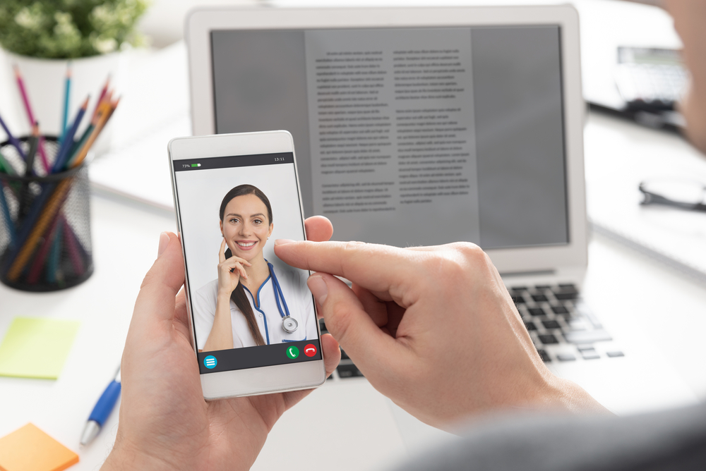Doctor with a stethoscope. Telehealth conference. Individual attends a virtual health session with a provider on a mobile device