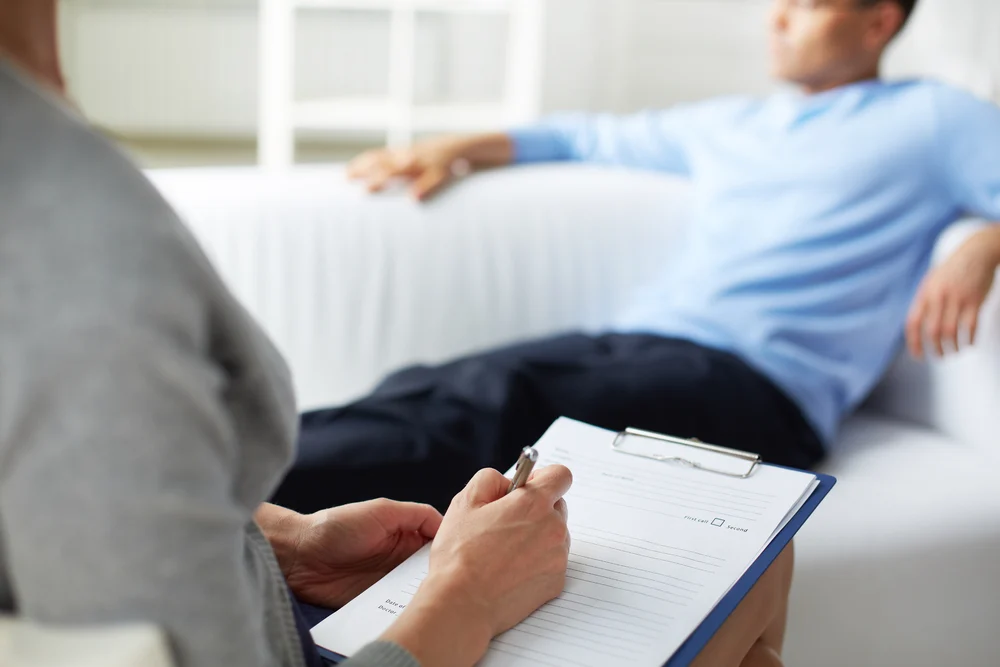 therapist taking notes during a substance abuse counseling session