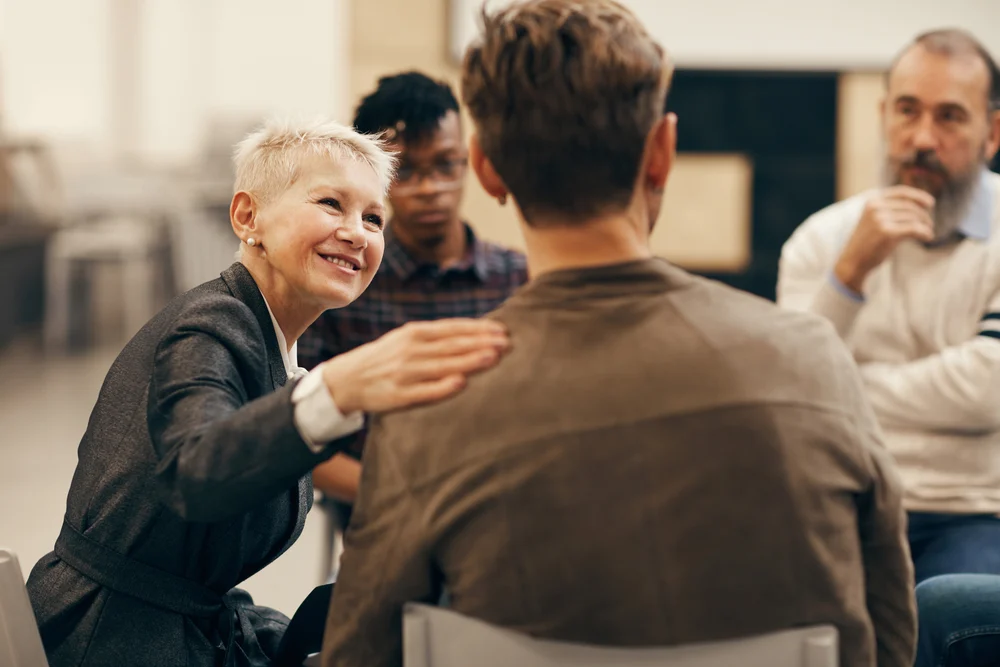 therapist comforting individual in empathetic group session