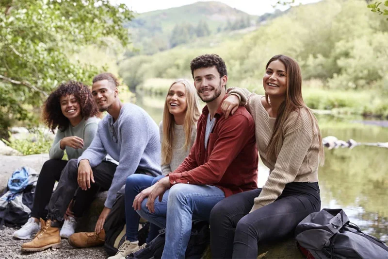 group of adults outdoors near water during experiential therapy activities that support recovery and emotional well-being