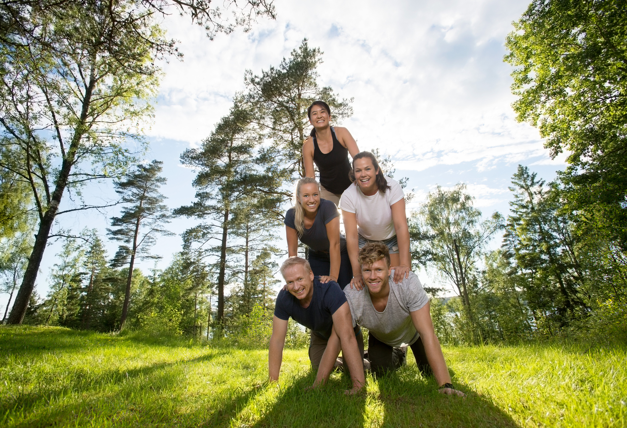 Group of people forming a human pyramid outdoors, symbolizing teamwork and support in connection with PacificSource rehab benefits