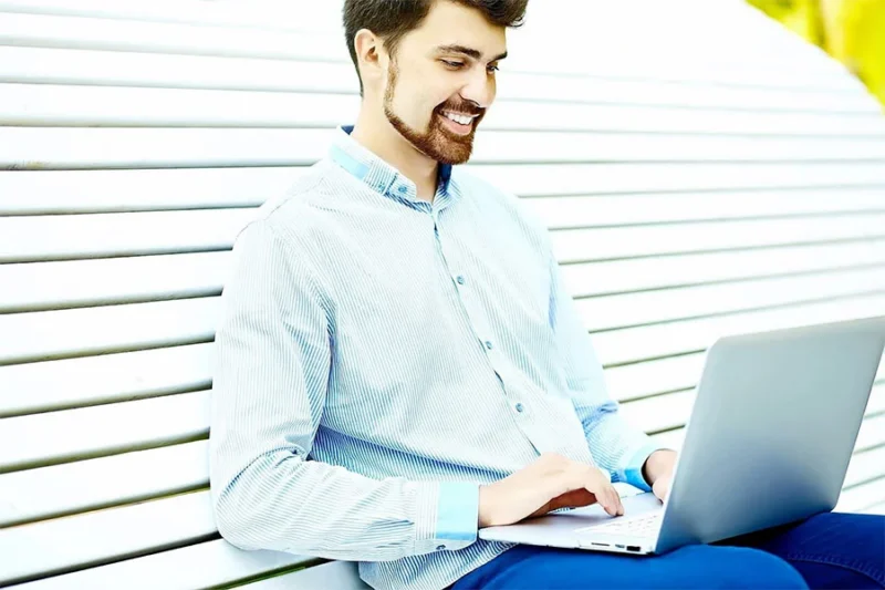 man using laptop for virtual iop session, participating in outpatient treatment remotely