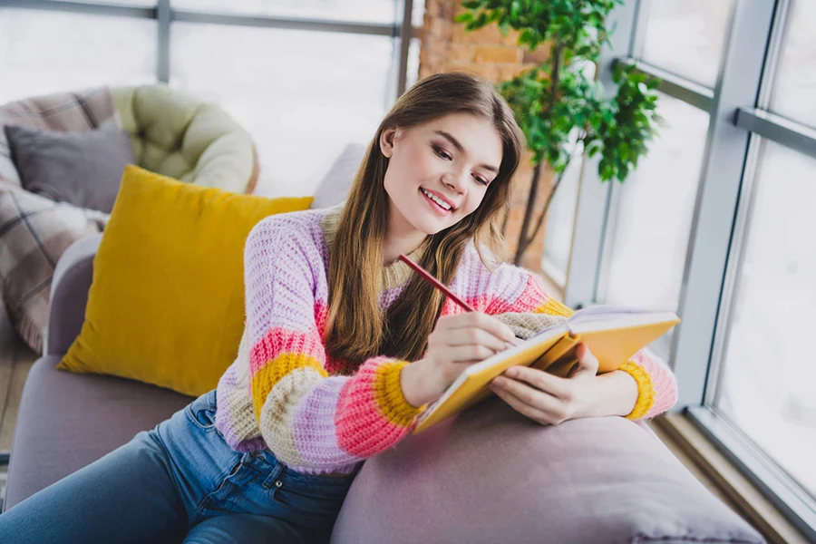 person journaling indoors during winter as part of addiction recovery self-care routine