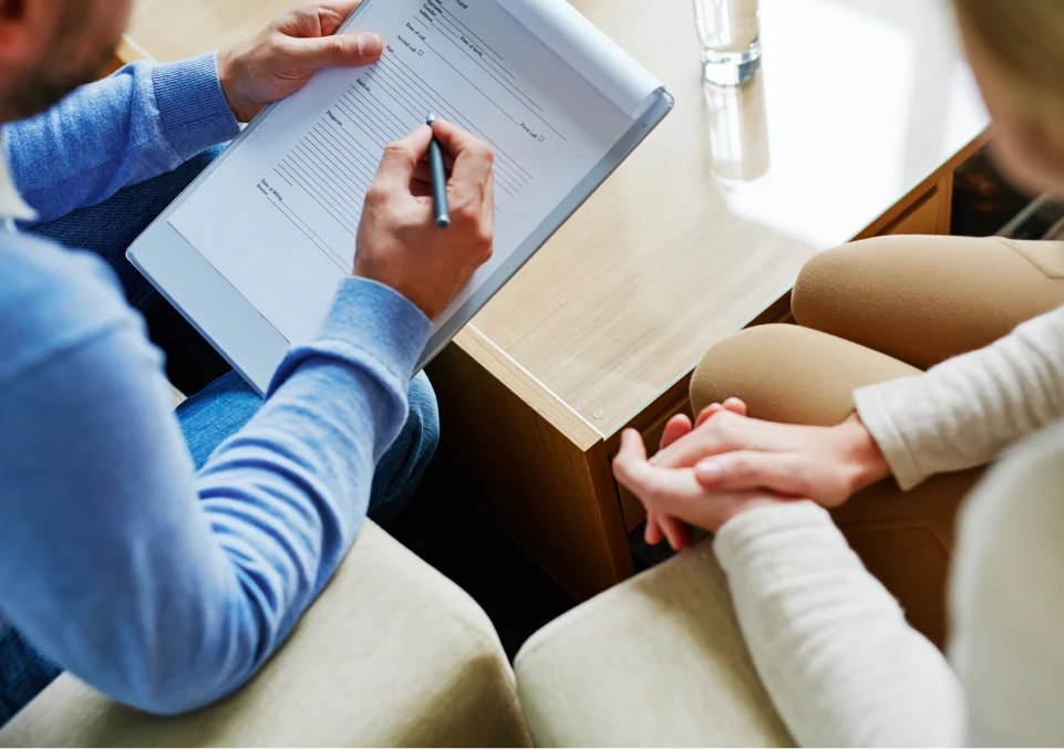 a person filling out a form during a session, likely related to recovery services for alcohol addiction therapy