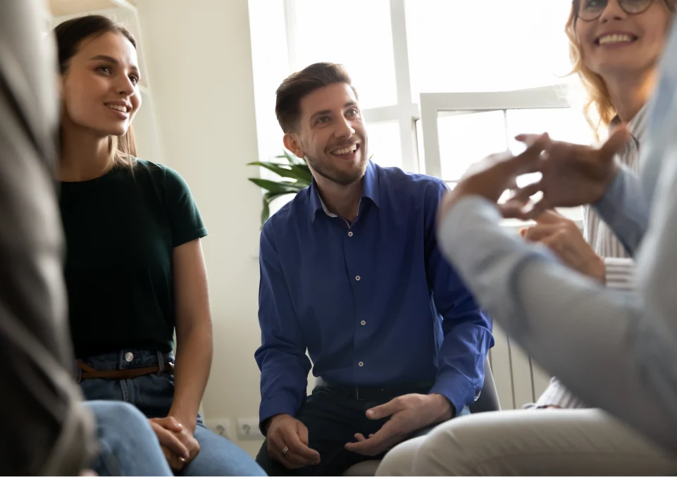 group of people smiling and discussing in an outpatient addiction and mental health program in montana