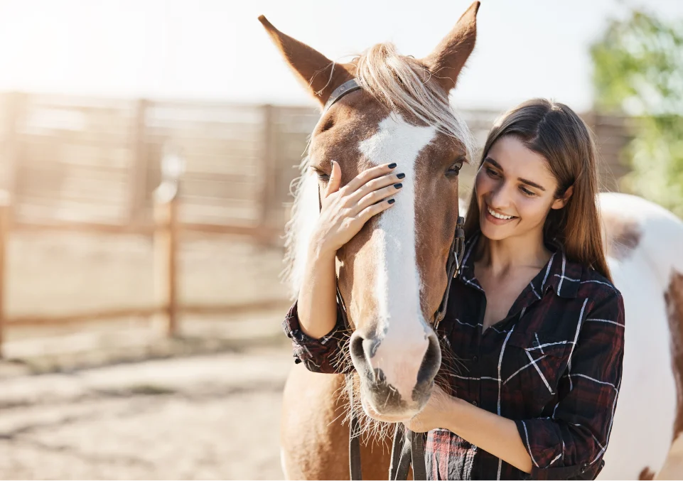 young woman bonding with a horse in an equine-assisted therapy session to alleviate negative emotions