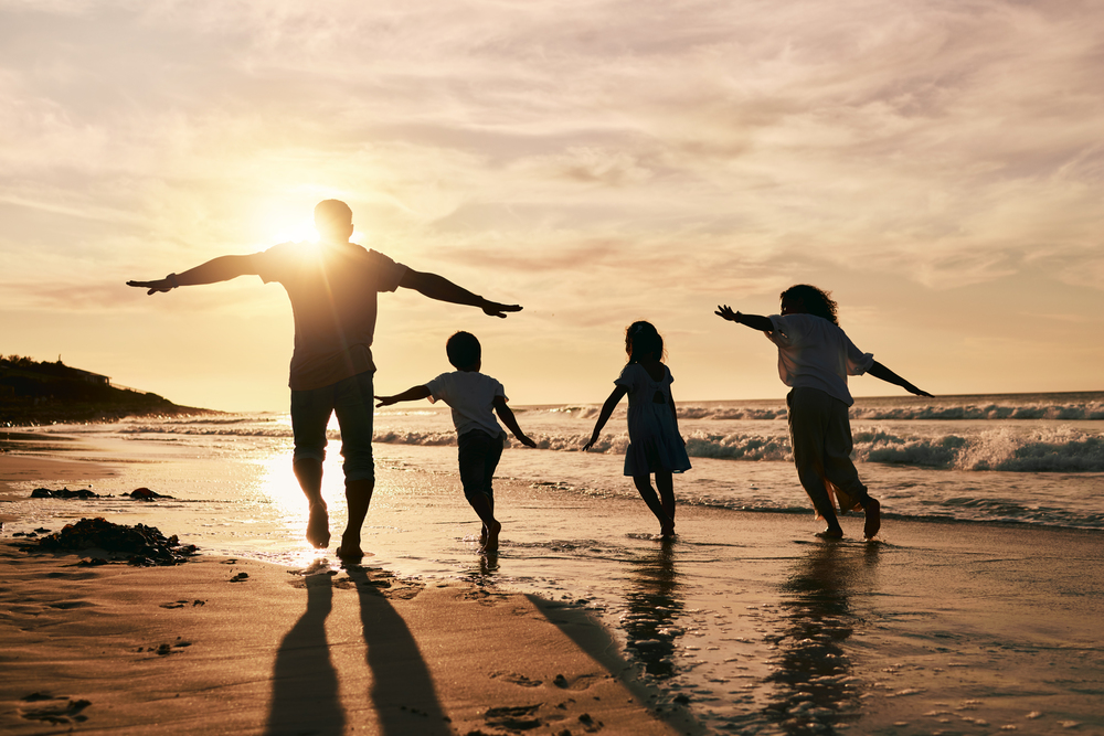 Signs of Drug Addiction Featured Image - Silhouette, family is running on beach and back view with ocean waves, sunset and bonding in nature.