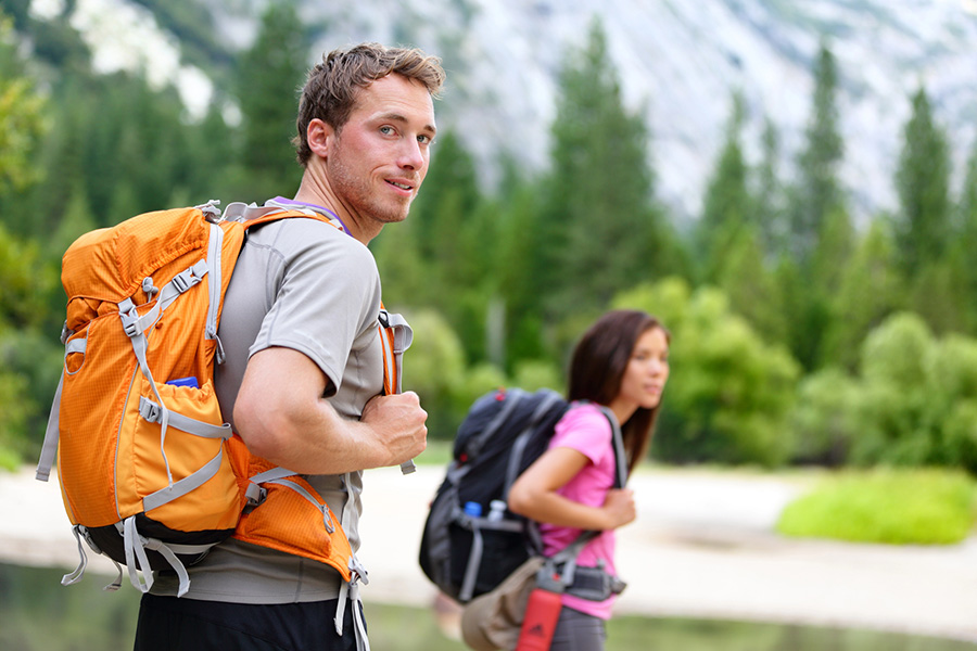 two people hike in a forest as part of an experiential substance abuse treatment program in montana.
