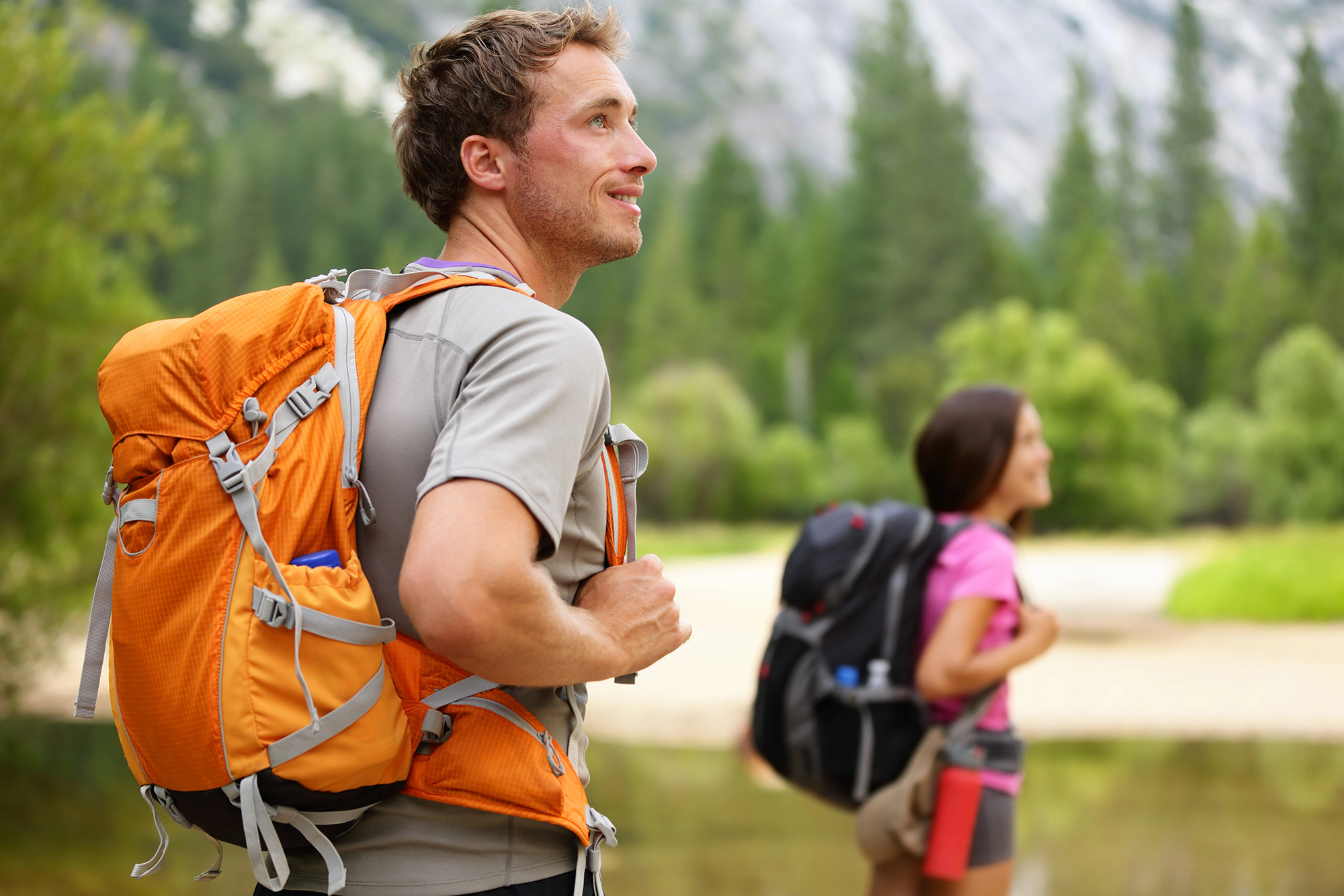 Two people hiking in a forest, representing the experiential therapy activities offered in addiction recovery programs