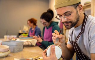 focused man and women engaging in a creative ceramics class activity