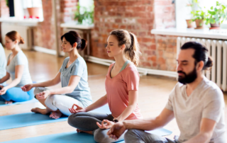 adults practicing mindfulness meditation in a wellness group session