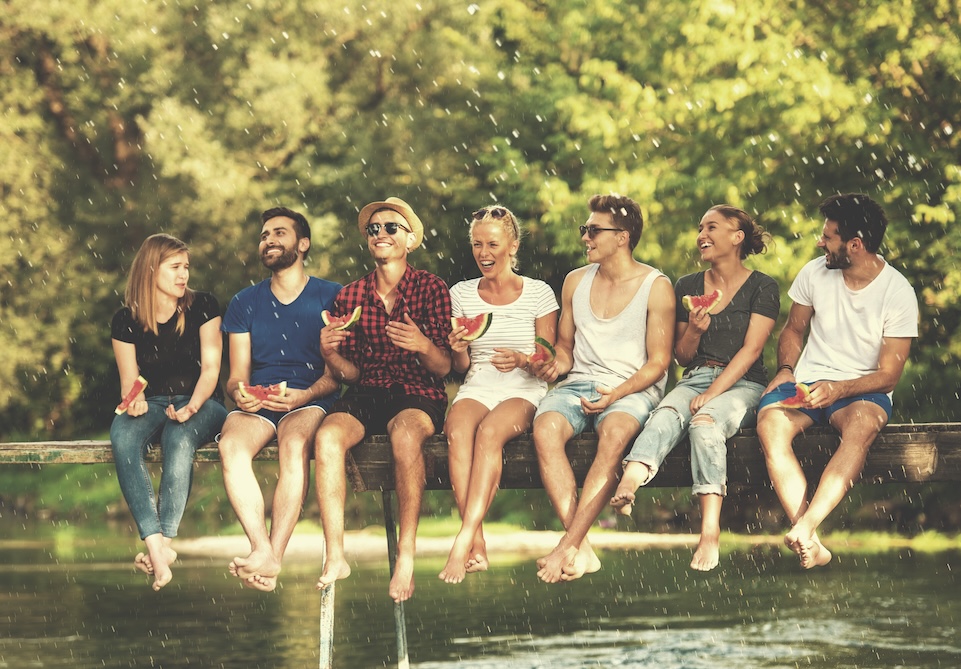 Group of friends enjoying watermelon on a dock, reflecting the joy in life after recovery Group of friends enjoying watermelon on a dock, reflecting the joy in life after recovery