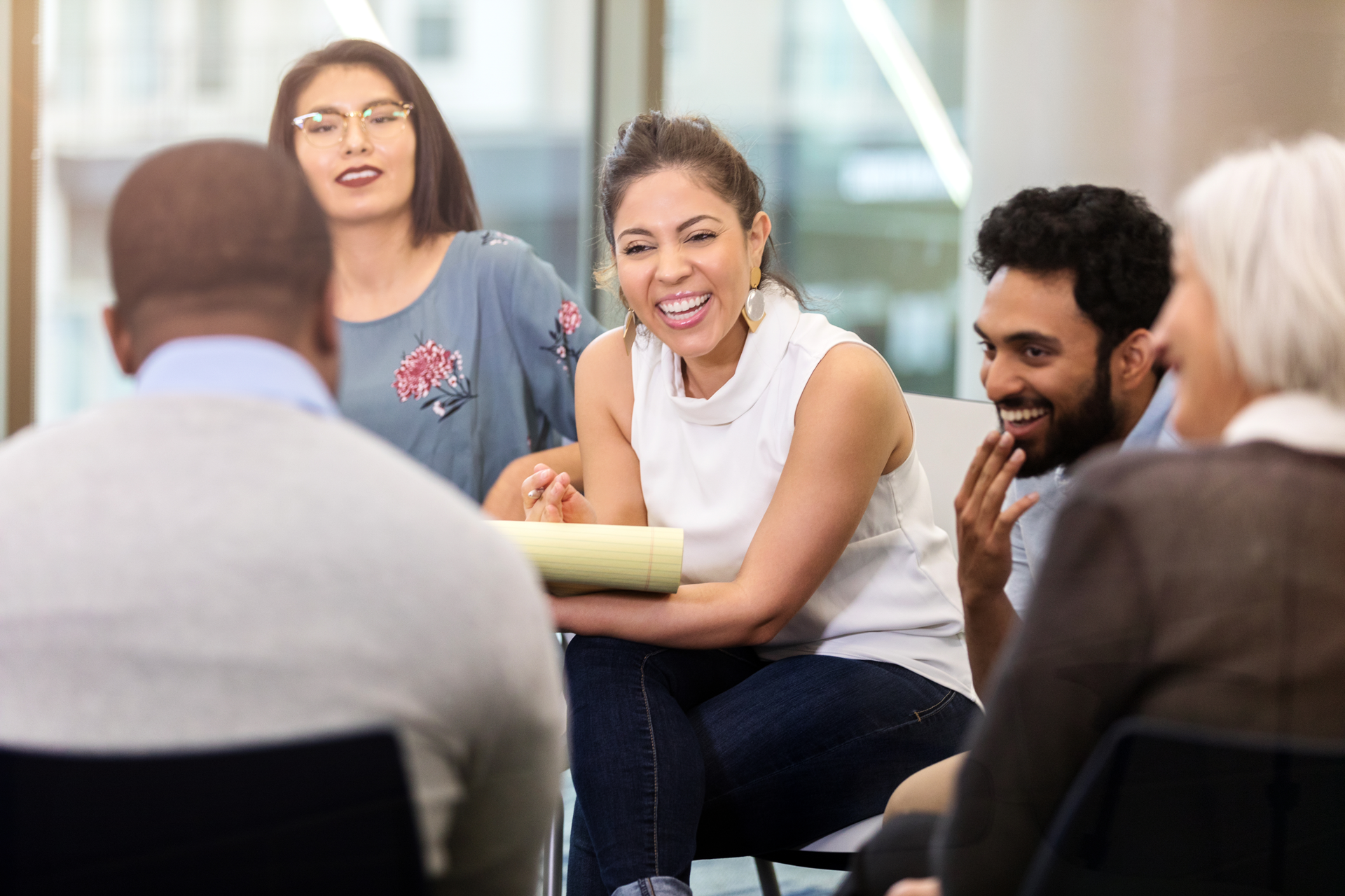 Smiling people participating in group therapy session, as part of a PTSD support group Happy people sharing positive emotions in a post-traumatic stress disorder treatment session