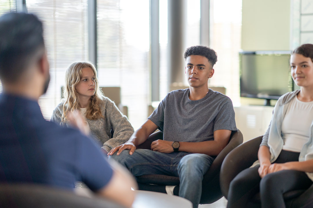 Adolescents engaged in a youth therapy services session