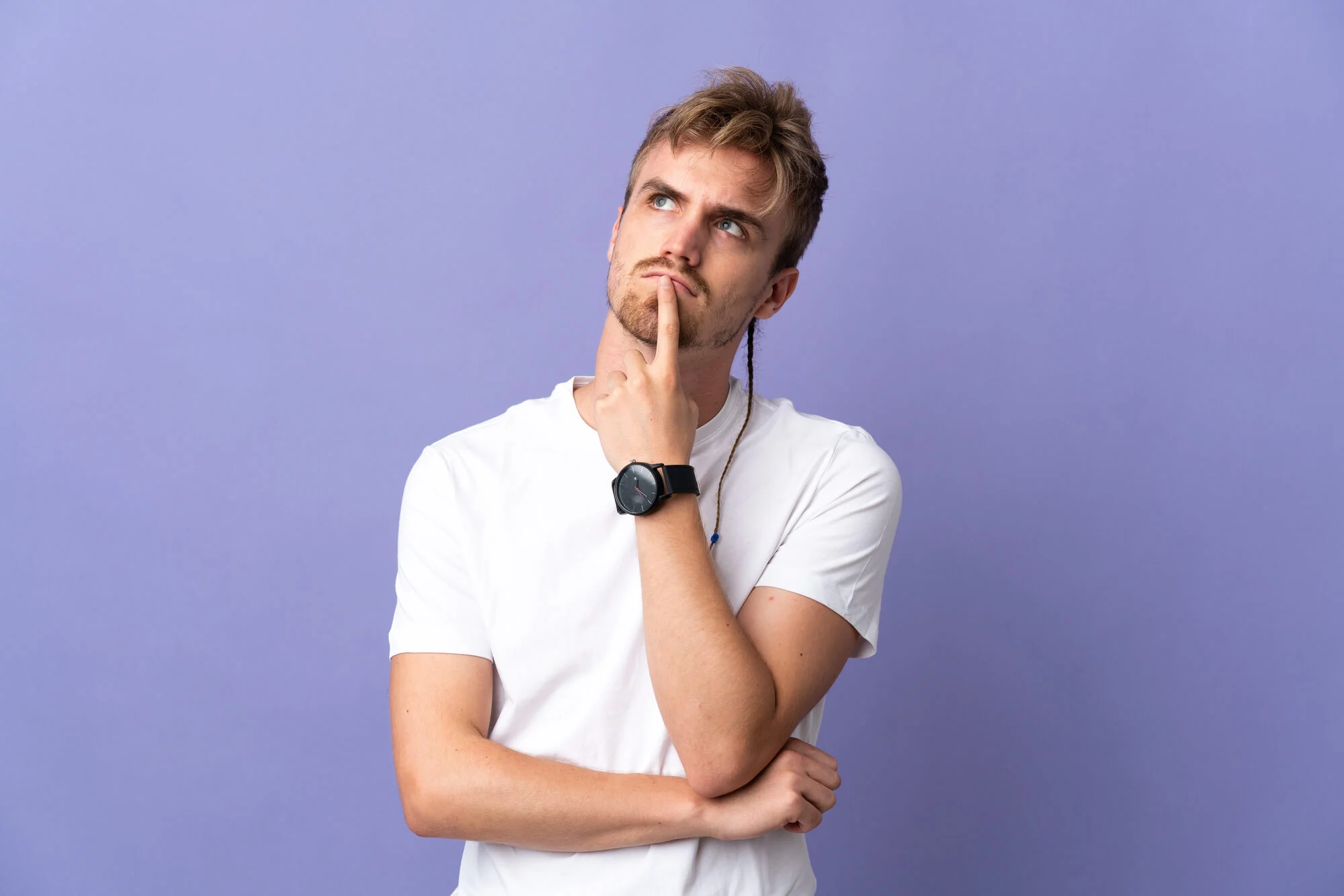a man with his finger up to his lips looking pensive about whether he has a weed addiction