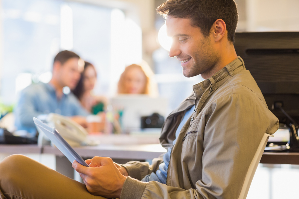 Smiling young man using digital tablet during his online individual therapy.