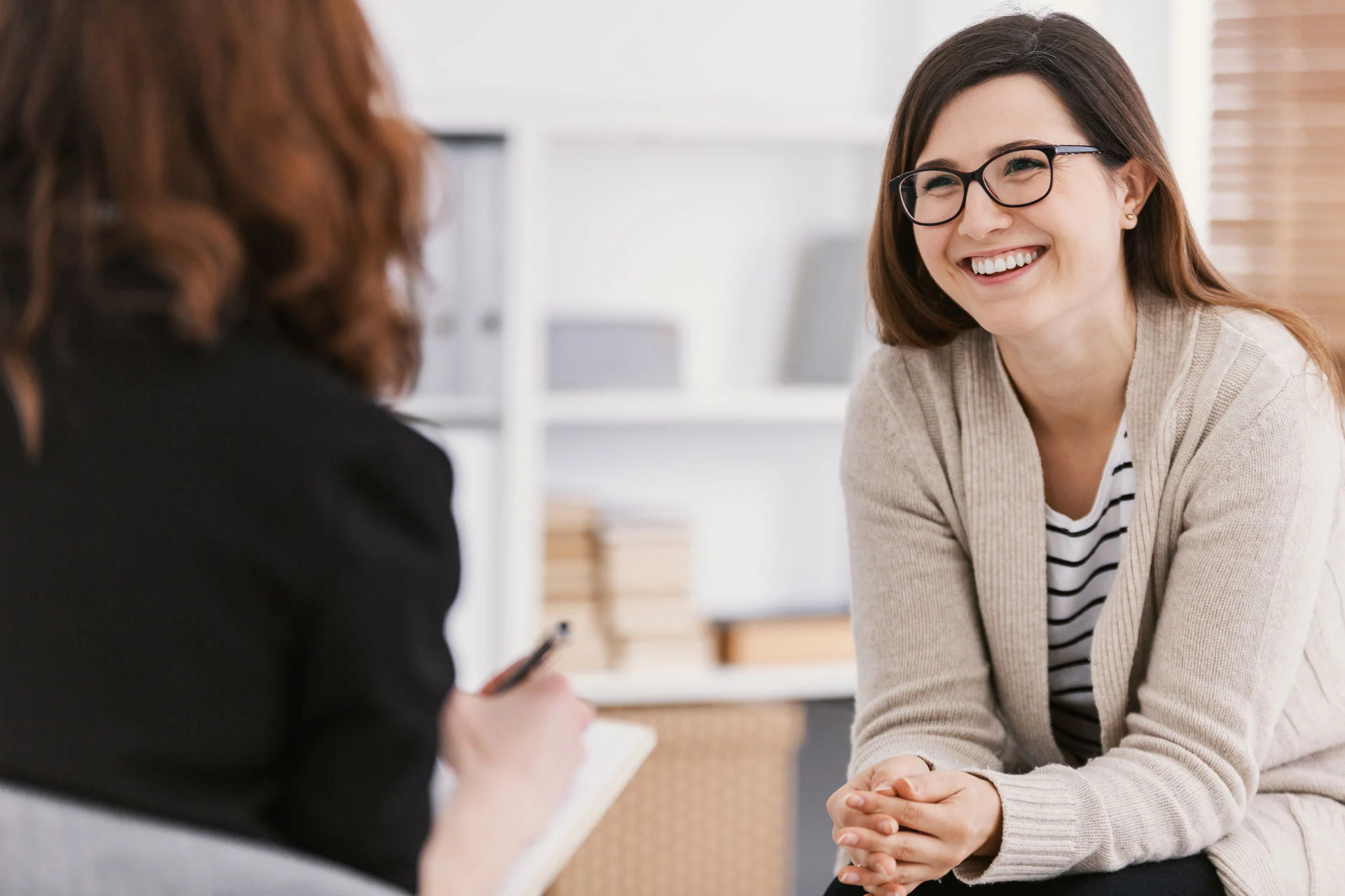 individual therapy session in outpatient psychiatric care with a smiling female patient and therapist