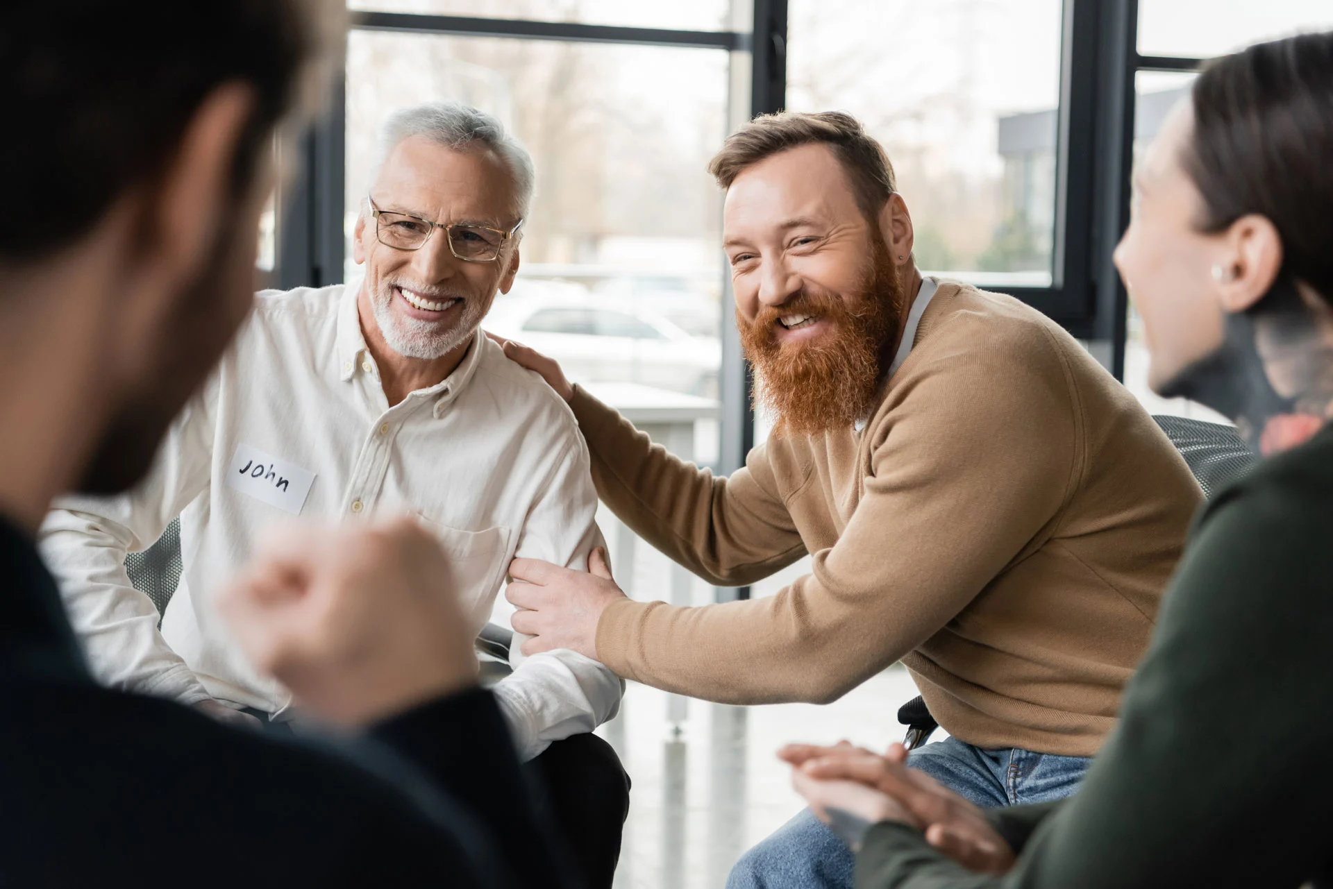 individuals laughing together in an adult outpatient program therapy session