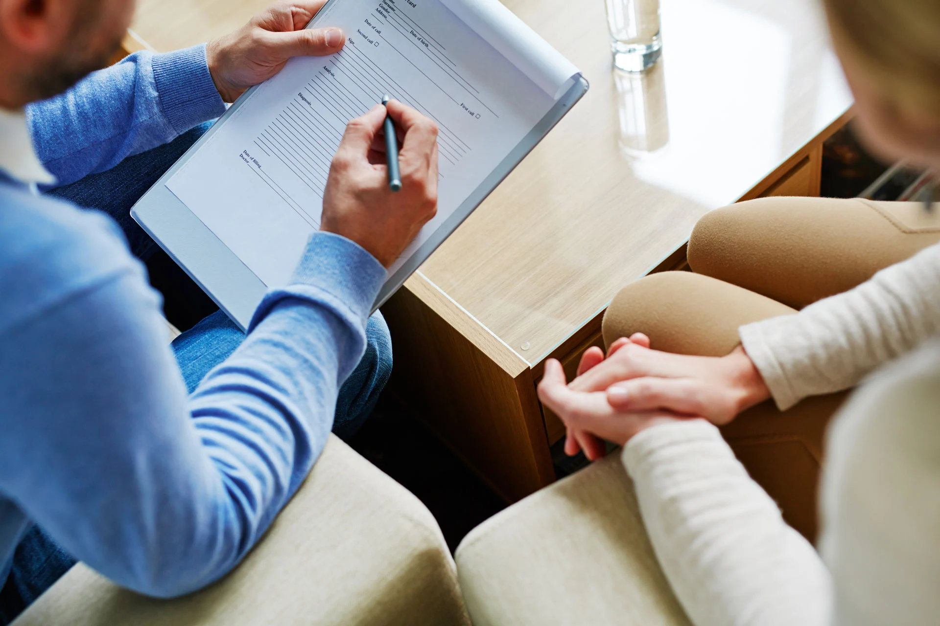 therapist filling out ptsd therapy plan during a counseling session with a patient