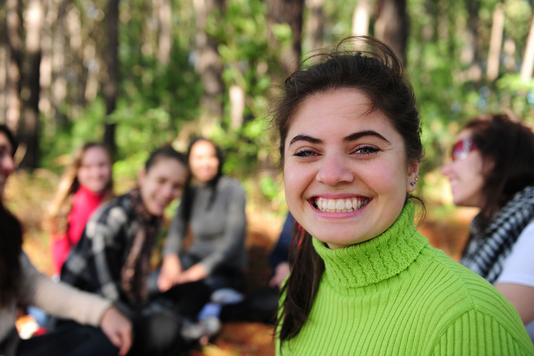 Teen girl smiling with friends, promoting adolescent coping skills development