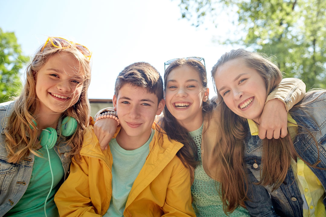 Happy teens bonding outdoors, exemplifying experiential therapy for teens