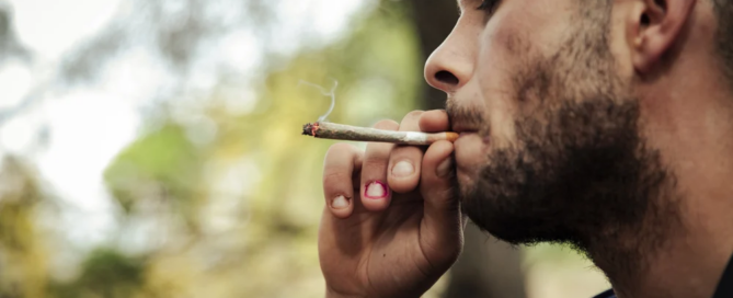 man smoking synthetic cannabinoids or synthetic thc to mimic marijuana effeects
