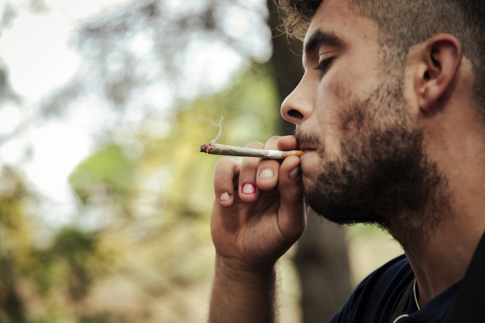 Man smoking synthetic cannabinoids or synthetic THC to mimic marijuana effeects