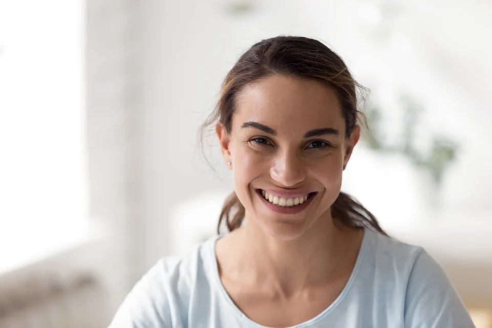 beaming woman in a light-filled room, evoking the hopeful spirit of big sky treatment's healing environment